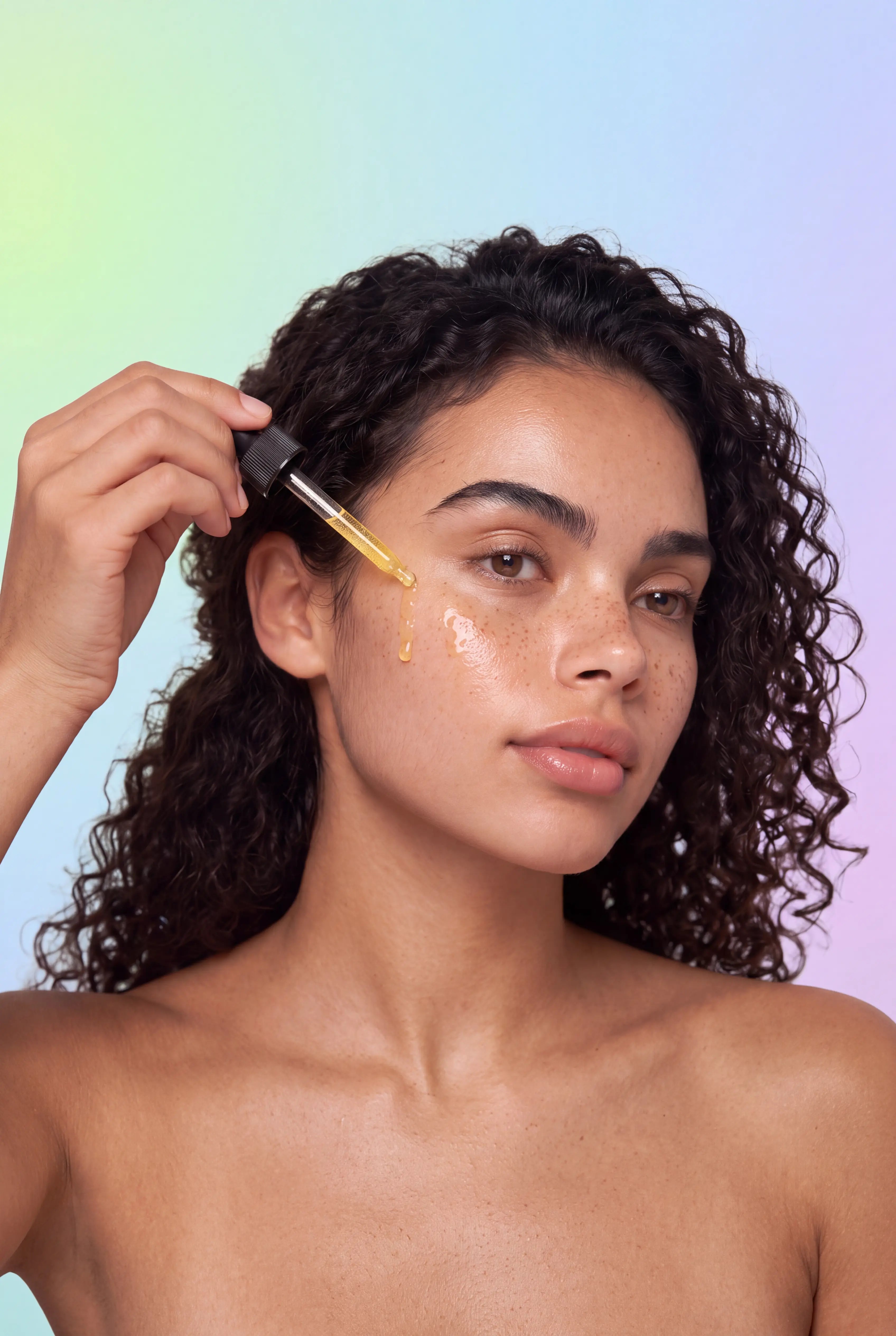 Model applying golden Lulu's Holistics Hyaluronic Acid Hydrating and Lightening Serum to face with a glass dropper