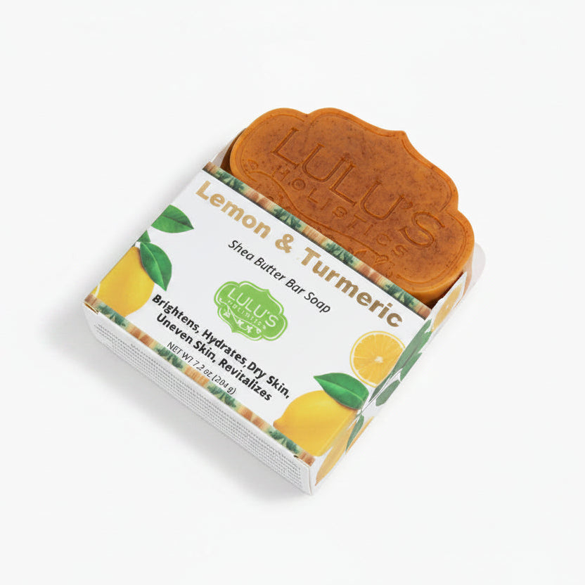 Lulu's Holistics Lemon & Turmeric Shea Butter Bar Soap partially unboxed, showcasing the handmade scalloped orange-brown bar alongside its vibrant, skin-brightening packaging.