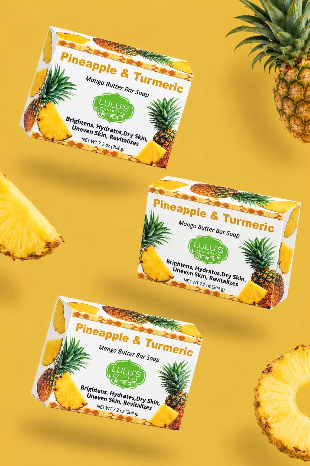 Video laden: Cinematic motion video showing three floating boxes of Lulu's Holistics Pineapple and Turmeric Mango Butter Bar Soap with moving shadows and drifting fresh cut pineapples on a yellow background
