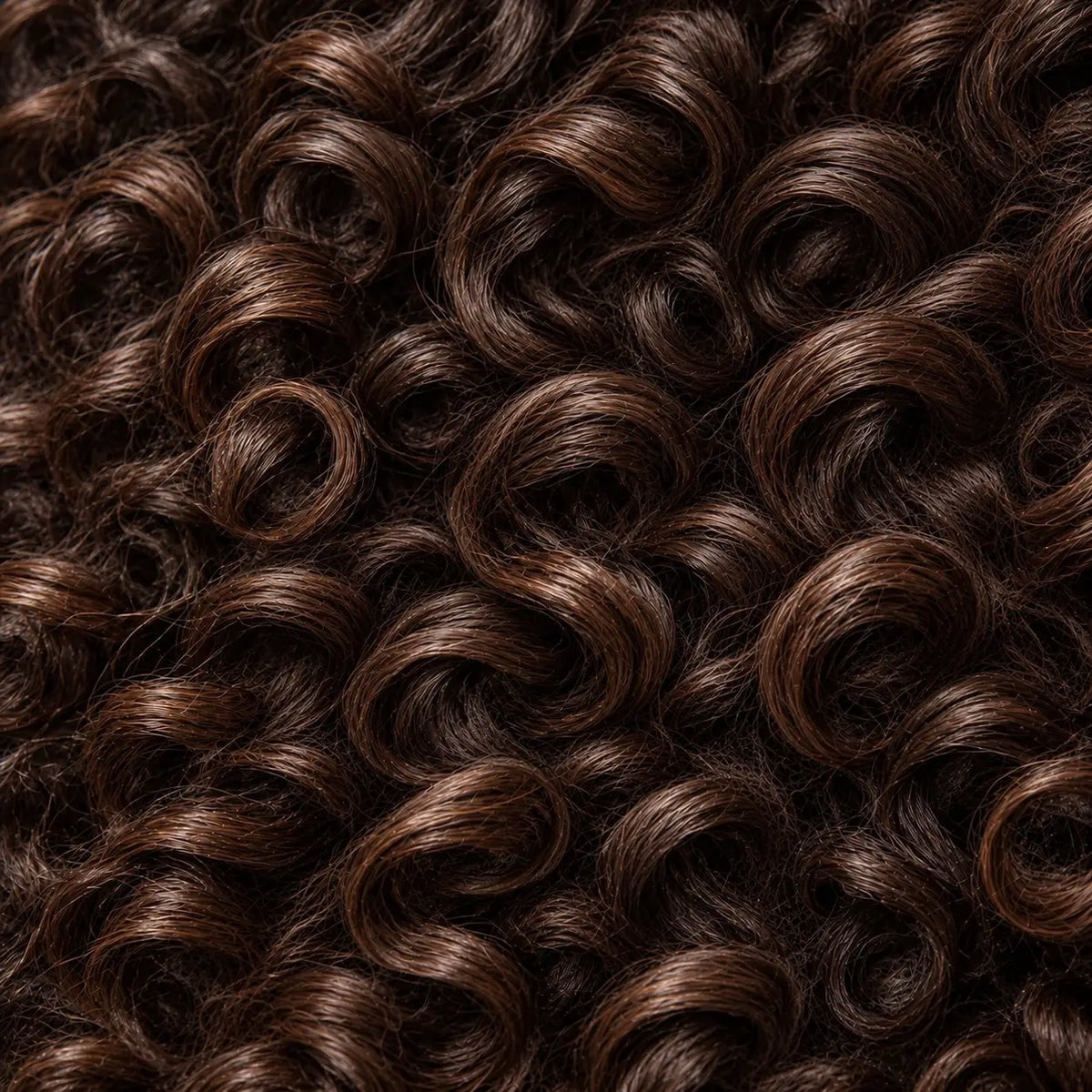 Close-up of healthy, defined, moisturized dark brown curls treated with Lulu's Holistics Vital hair care.