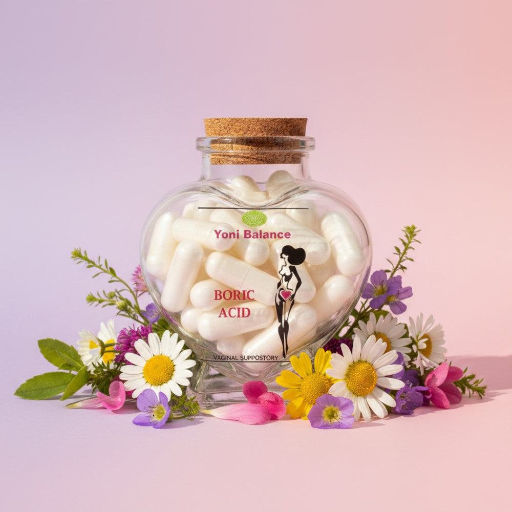 Lulu's Holistics Yoni Balance Boric Acid Suppositories in a heart-shaped glass bottle surrounded by colorful wildflowers on a soft pink background.