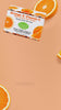 E-commerce product video showcasing a floating box of Lulu's Holistics Orange and Vitamin C Mango Butter Bar Soap with animated lighting and rotating fresh orange slices on a peach background