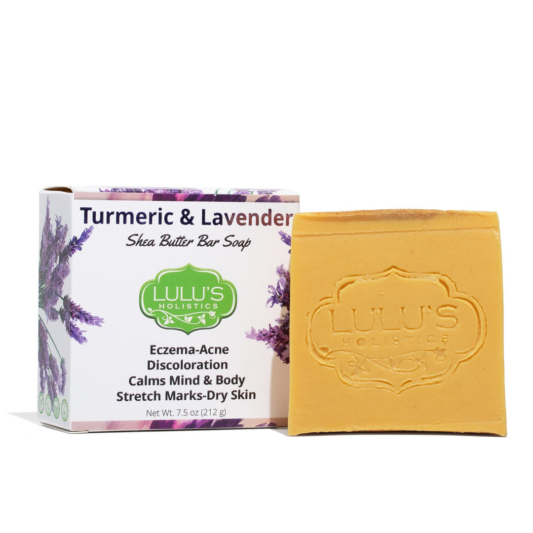 A creamy bar of Lulu's Holistics Turmeric and Lavender Shea Butter Soap displayed with natural ingredients. Shop this gentle cleanser online to naturally fade dark spots, soothe eczema, and clear acne globally.