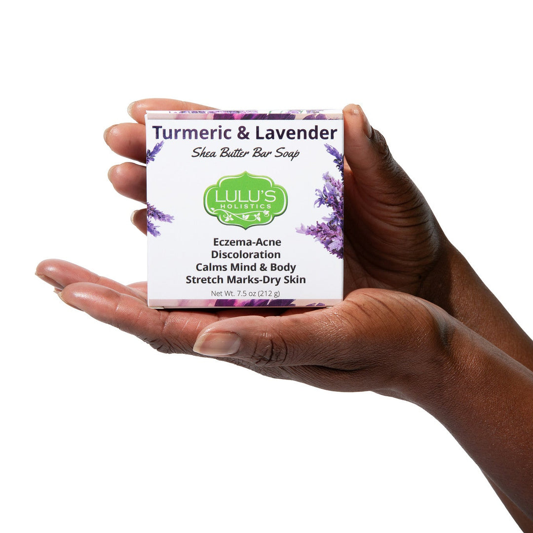 A hand holding Lulu's Holistics Turmeric and Lavender Soap. The ideal natural remedy available online if you need a calming cleanse for eczema, acne, and discoloration.